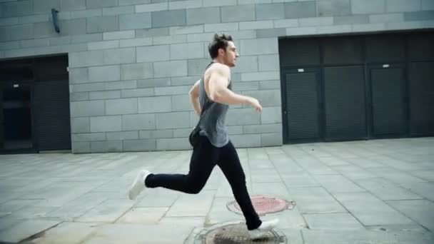 Fitness man running on urban street in slow motion. Male runner jogging outdoor. — Stock Video