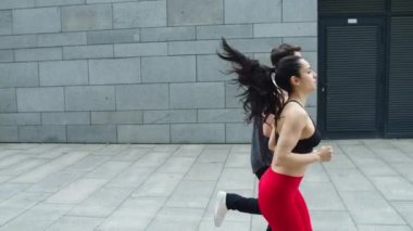 Fitness çifti dışarıda koşuyor. Sporcu kadın ve erkek birlikte koşuyorlar.