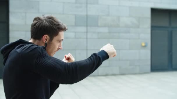 Närbild idrottsman boxning med knytnäve utomhus. Boxningsslag för män — Stockvideo