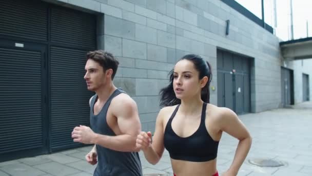 Closeup sporty couple starting run outdoor. Focused couple running together — Stock Video