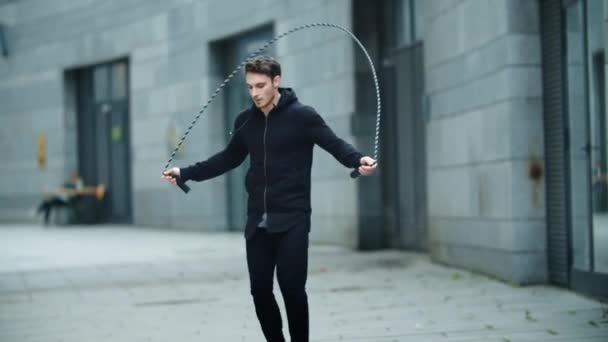 Вмістити чоловіка тренувати стрибок вправи на пропускаючи мотузку на тренуваннях. Спортсмен стрибає — стокове відео