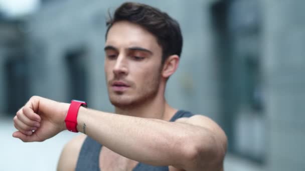 Closeup male athlete using smart clock outside. Fit man setting smart watch — Stock Video