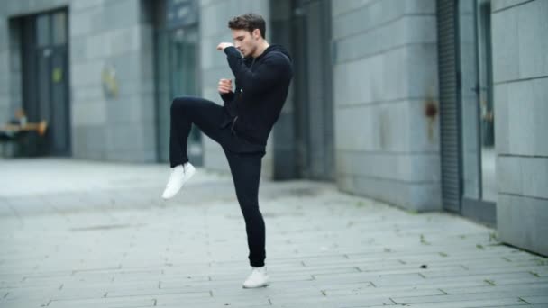 Boxer wärmt sich beim Straßentraining auf. Fitness-Mann streckt die Beine — Stockvideo