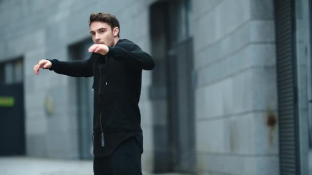 Homem atleta fazendo exercício de aquecimento para os braços ao ar livre. Pontapé de mão de treinamento de lutador — Vídeo de Stock