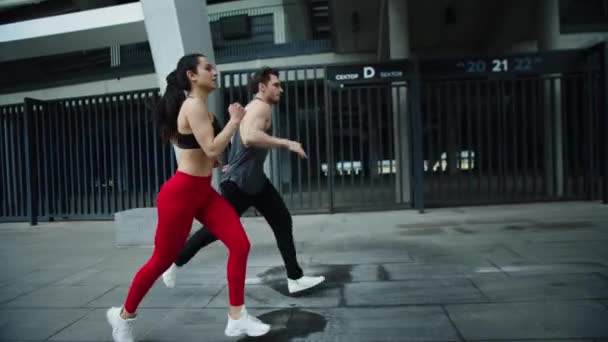 Pareja de deportes corriendo en el entrenamiento cardiovascular. Fitness hombre y mujer corriendo juntos — Vídeos de Stock