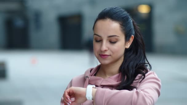 Primer plano chica bonita buscando mensaje en el reloj de fitness en cámara lenta . — Vídeos de Stock