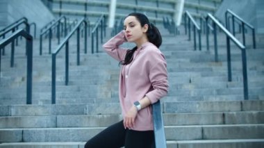 Spor salonundaki kadın merdiven boşluğunda dinleniyor. Genç bayan model merdivenlerde poz veriyor.