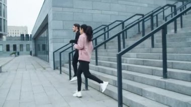 Dışarıdaki merdivenlerden koşan spor salonu çifti. Spor çifti antrenmanı.