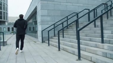 Spor adam merdivenlerden dışarı koşuyor. Fitness adamı eğitim koşusu egzersizi