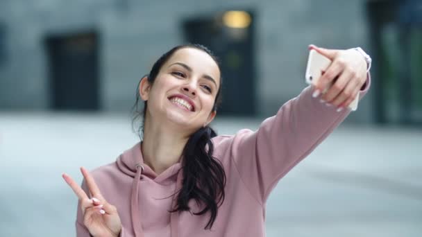 Fechar mulher alegre posando para foto selfie. Mulher feliz mostrando sinal de vitória — Vídeo de Stock