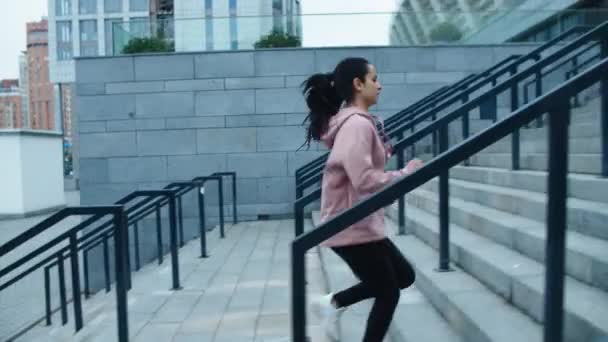 Αθλητής γυναίκα τρέχει μέχρι σκάλες για υπαίθρια προπόνηση. Ένα γυμνασμένο κορίτσι τρέχει επάνω. — Αρχείο Βίντεο