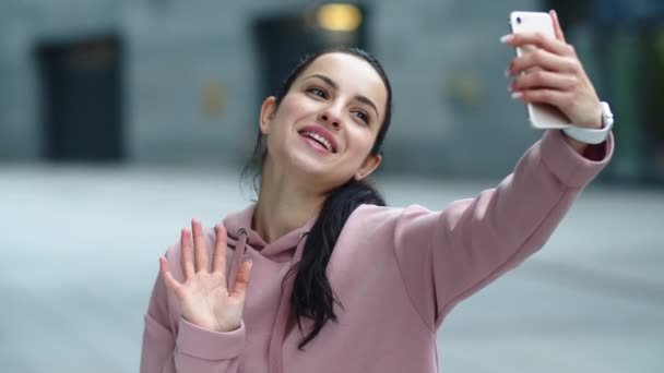 Närbild leende kvinna vinka hand till kamera. Lycklig flicka med mobiltelefon — Stockvideo