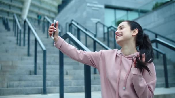 Closeup sorrindo mulher posando para selfie foto ao ar livre. Jovem mulher tocando cabelo — Vídeo de Stock