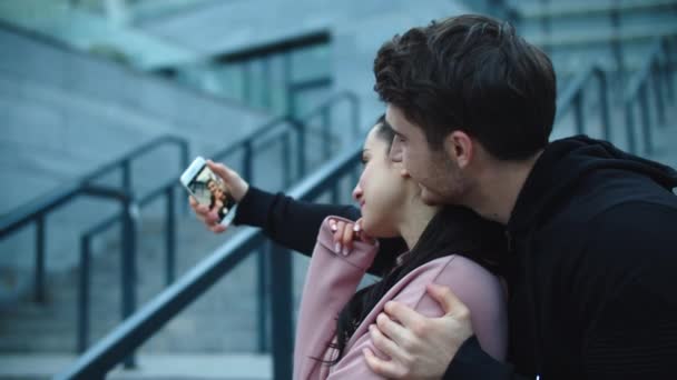 Casal apaixonado tirando foto de salfie ao ar livre. Abraçando casal posando para selfie — Vídeo de Stock
