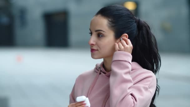 Mujer sonriente de primer plano con auriculares inalámbricos. Deportiva mujer disfrutando de la música — Vídeo de stock