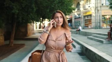 Cep telefonuyla yürüyen odaklanmış bir kadın. Yakın plan seksi kadın cep telefonu görüşmesi yapıyor..