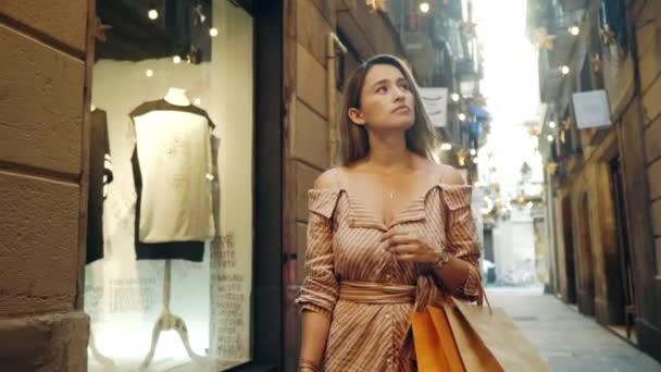 Turista mujer caminando con bolsas de compras. Chica mirando en los escaparates. — Vídeos de Stock