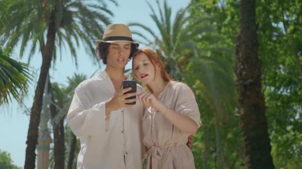 Closeup tourist couple looking mobile phone. Happy friends searching direction — Stock Video