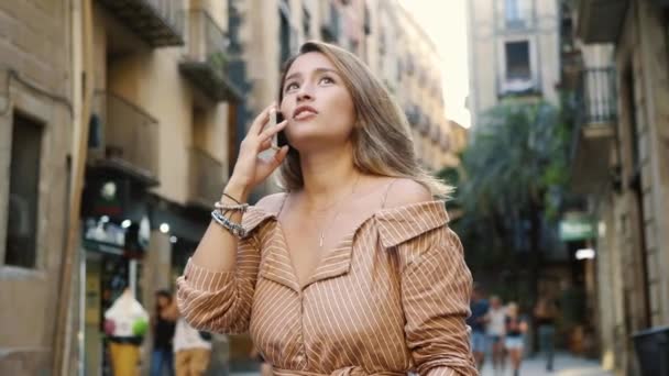 Retrato de una mujer disgustada hablando de teléfono móvil. Chica enojada mirando reloj de mano — Vídeos de Stock