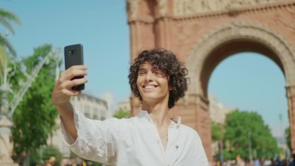 Mosolygó ember portréja, amint szelfi fotót készít. A fickó kacsint a mobilképre. — Stock videók