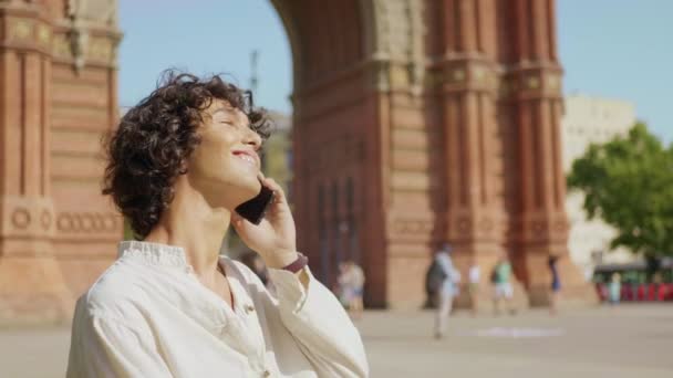 Porträt eines lächelnden Mannes, der im Freien mit seinem Handy telefoniert. Glücklicher Mann im Ziel — Stockvideo