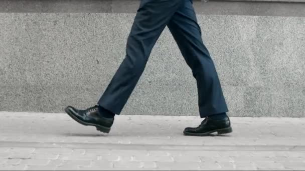 Hombre de negocios piernas caminando en zapatos negros. Primeros planos zapatos negros caminando al aire libre — Vídeo de stock