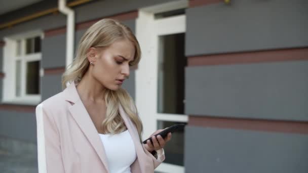 Donna in primo piano che chiacchiera al telefono all'aperto. Donna che cammina con il telefono in strada. — Video Stock