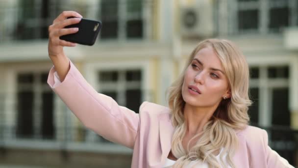 Porträtt flicka gör selfie på gatan. Affärskvinna fotografering i rosa kostym — Stockvideo