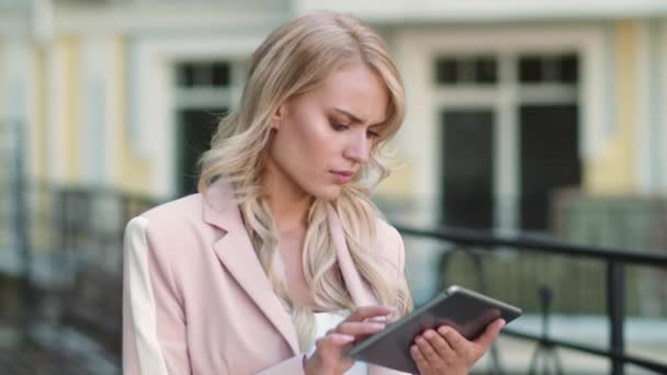 Nahaufnahme einer aufgebrachten Frau, die draußen am Touchpad arbeitet. Person mit Tablet im Freien — Stockvideo