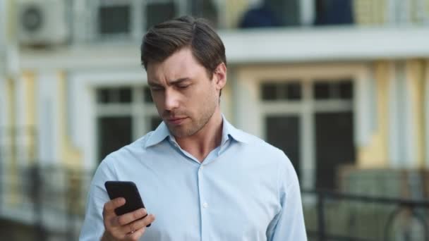 Closeup man typing on phone at street. Businessman using smartphone outdoors — Stock Video