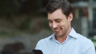 Sokakta akıllı telefon kullanan yakın plan bir iş adamı. Dışarıda telefonda yazan adam.