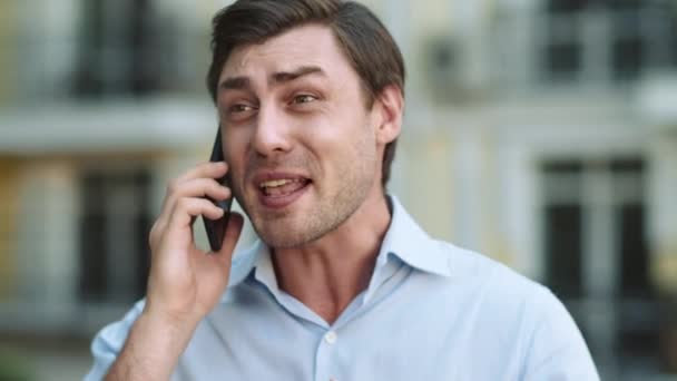 Portret van een serieuze man met een telefoongesprek. Boze zakenman aan het praten op smartphone — Stockvideo