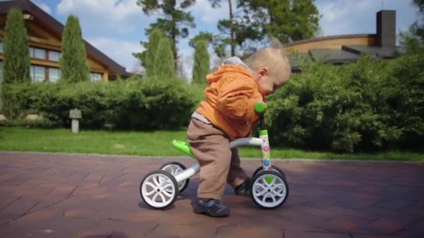 小さな子供が最初に自転車に乗ってみます。スローモーションでサイクルに乗って焦点を当てた少年. — ストック動画