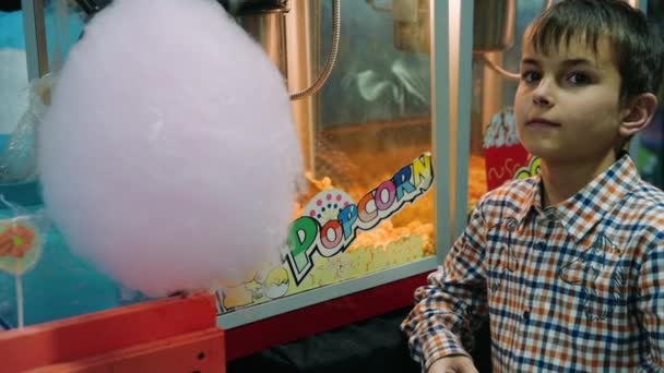 Een close-up jongen in de buurt van een popcorn machine. Portret van tiener poseren camera — Stockvideo