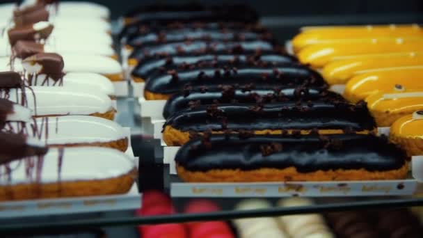 Tasty choux pastry lying at shop showcase. Macro of flavor cakes at patisserie. — Stock Video