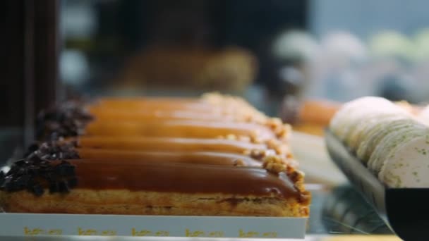 Closeup zoete bakkerij liggend op glazen kast. close-up kleurrijke macaron op vitrine. — Stockvideo