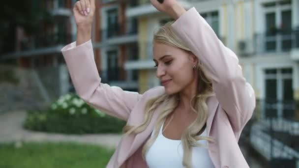 Close-up gelukkig zakenvrouw dansen met telefoon in de hand outdoor — Stockvideo