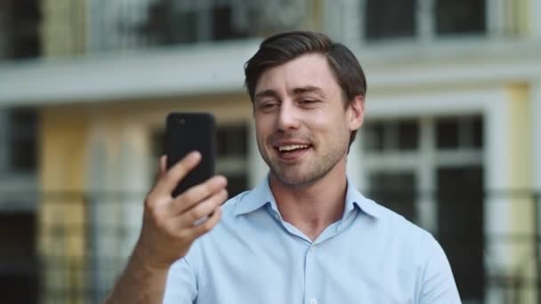 Closeup zakenman met behulp van telefoon voor videogesprek. Man met videochat op straat — Stockvideo