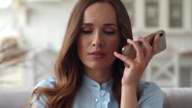 Odaklanmış iş kadını portresi oturma odasında telefon görüşmesi yapıyor..