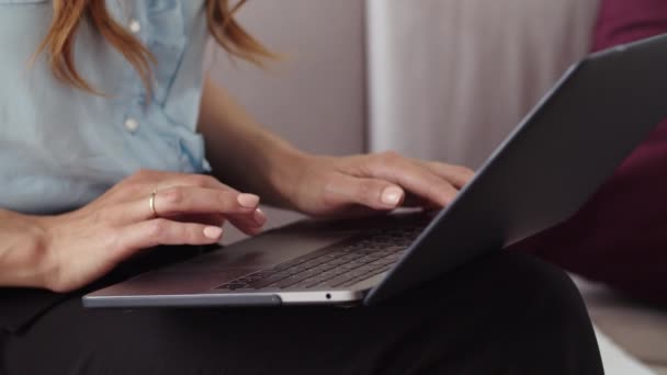 Weibliche Hände tippen auf dem Laptop im entfernten Büro. Mädchen arbeitet an Notizbuch. — Stockvideo