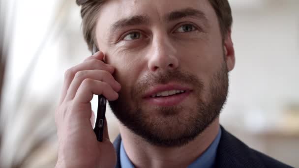 Un uomo d'affari sorridente che parla al telefono emotivamente a casa. Un tizio che chiama il cellulare. — Video Stock