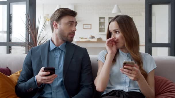 Jeune femme parlant à son mari à la maison. Couple naviguer sur Internet sur les téléphones. — Video