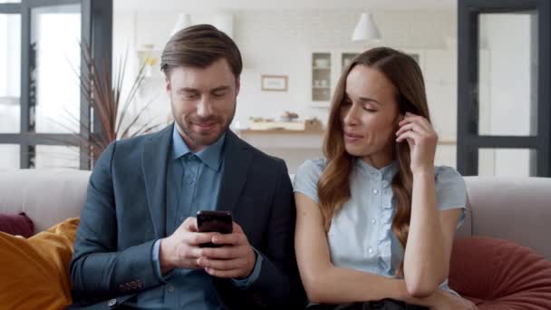 Obchodní pár sedí s telefonem v kanceláři. Šťastný pár se baví — Stock video