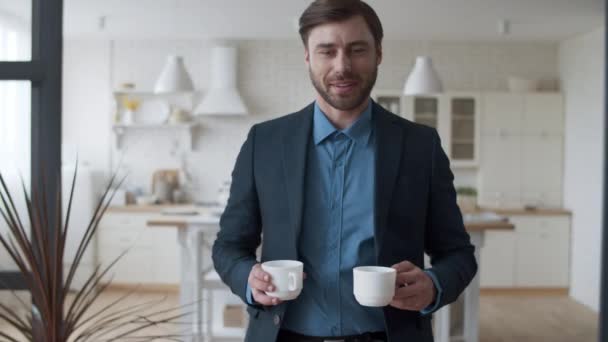 Amando a la pareja familiar haciendo una pausa para tomar café en casa. Hombre trayendo tazas de té a la esposa. — Vídeos de Stock