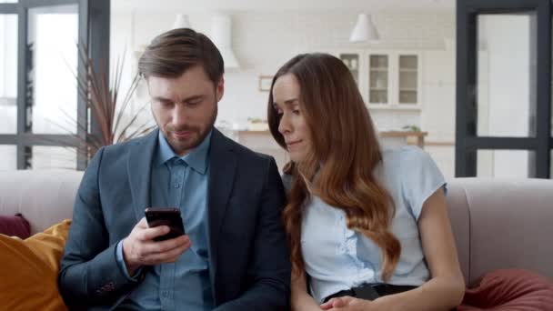 Couple d'affaires se détendre sur le canapé ensemble. Femme agacée regardant téléphone homme — Video