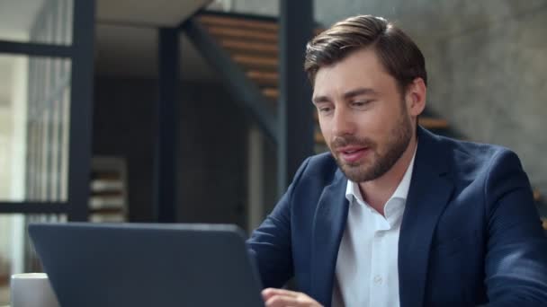 Homme d'affaires souriant travaillant avec un ordinateur portable et des papiers dans le bureau. — Video