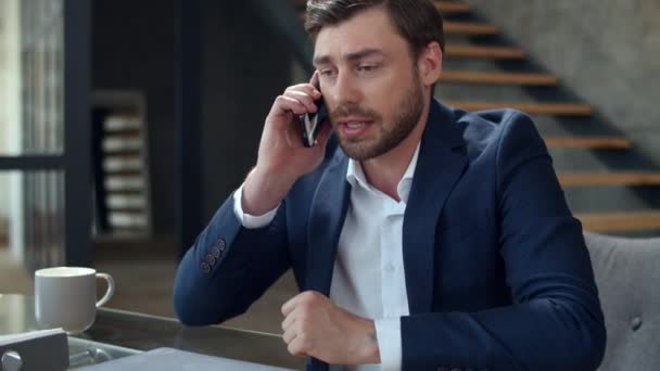 Злой бизнесмен эмоционально разговаривает по телефону в офисе. Мужчина звонит по телефону. — стоковое видео