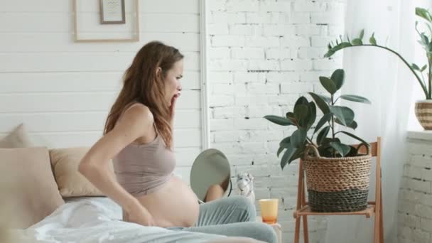 Uma mulher grávida a levantar-se no quarto. Mãe expectante sentindo náuseas em casa . — Vídeo de Stock