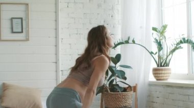 Pregnant woman getting up bedroom. Expectant mother standing near window home.