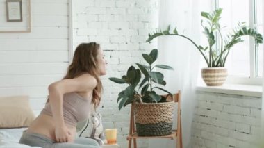 Expectant mother suffering pregnant pain at home. Pregnant woman in bedroom.